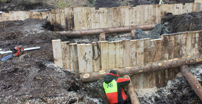 Schwere Holzkonstruktionen kommen in den Boden, um den Torf nass zu halten.